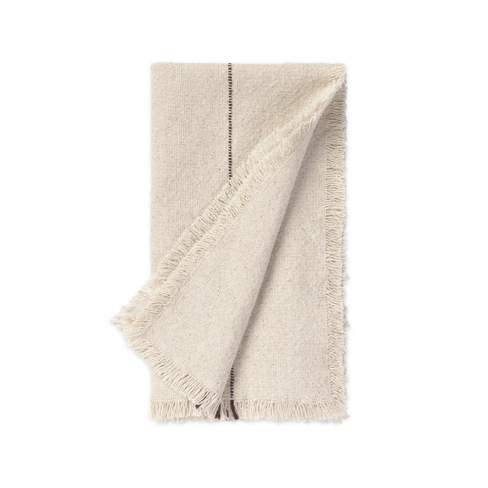 A folded cream-colored woven napkin with fringed edges and a single dark vertical stripe detail, shown on a solid white background.