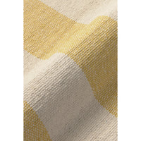 A close-up of a woven textile with a soft chevron pattern in pale yellow and warm off-white, showing the detailed texture of the fabric.