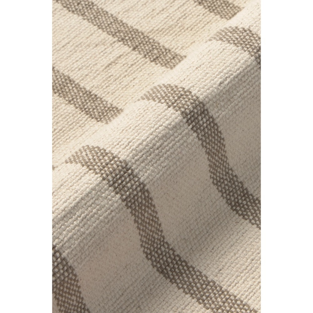 Close-up of a woven placemat with a cream base and taupe-gray stripe pattern.