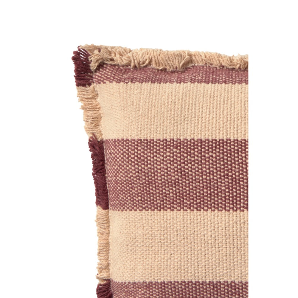 Close-up of a woven throw pillow corner showing horizontal stripes in beige and dusty rose with fringed edges on a white background.
