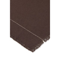 A close-up of a dark brown woven tablecloth showing a fringed edge and a thin light-colored stitched detail against a white background.