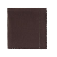 A dark brown woven tablecloth showing a fringed edge and a thin light-colored stitched detail