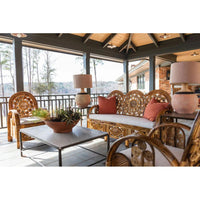 Outdoor patio furniture set with wicker chairs and table on a covered deck.