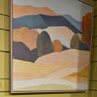 Framed abstract landscape painting on a yellow wall