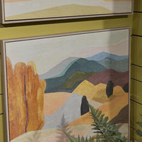 Two framed landscape paintings on a yellow wall.