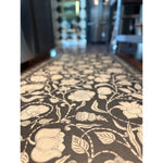 Close-up of Spicher and Company's My Dear And Loving Husband Antique Floral Vinyl Floor Mat on a kitchen floor.