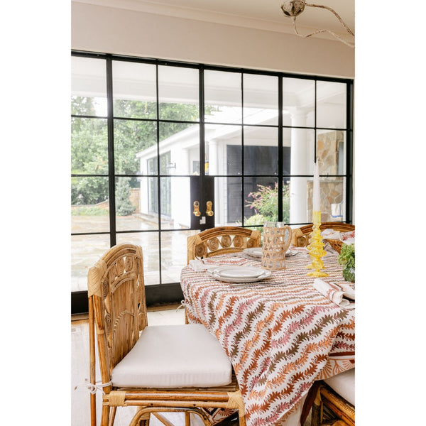 Dining room with a table set for a meal, featuring a large window with black frames.