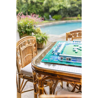 Outdoor setting with a pool and wicker furniture featuring a game board on a table.