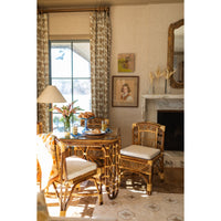 Dining room with wicker table and chairs, lamp, and decorative elements.