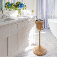 Bathroom with marble vanity, wicker champagne stand, and bathtub.