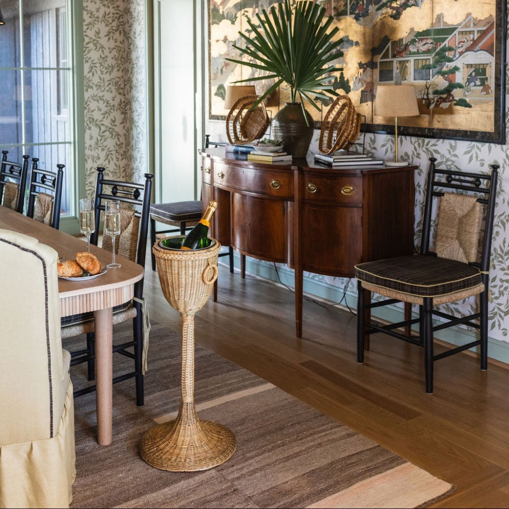 Dining room with wooden furniture, wicker chair, and decorative elements.