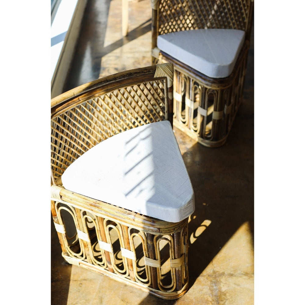 Wicker chair with white cushion on a wooden floor