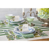 Elegant table setting featuring floral plates, green goblets, candles, and name cards reading "Seb" and "Ben" on a Hester & Cook Dark Green Classic Stripe Paper Runner.