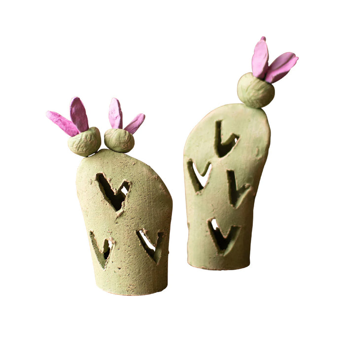 Two ceramic cactus-shaped incense burners with pink floral tops on a white background
