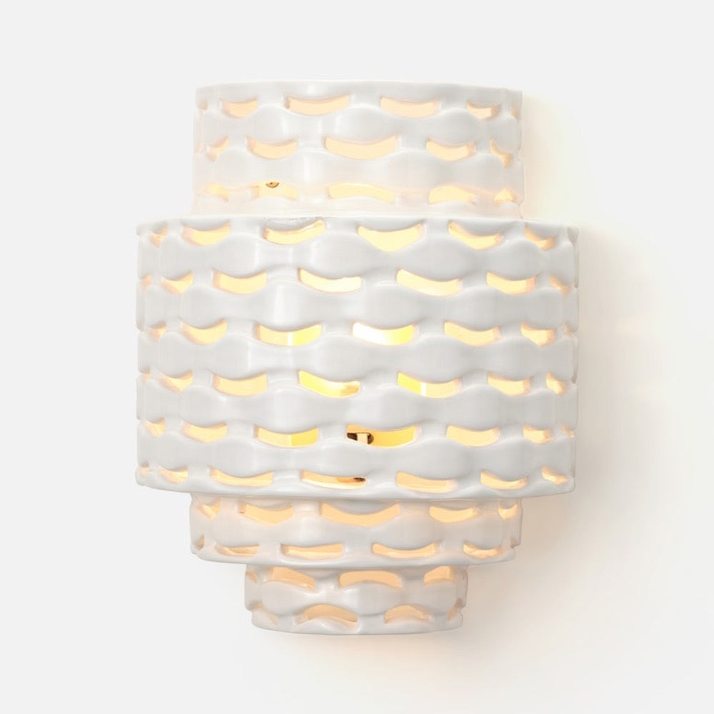 The Made Goods Omiros White Gloss + Gold Sconce features wavy layers and warm light shining through abstract cutouts.