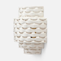 The Omiros White Gloss + Gold Sconce by Made Goods features an abstract silhouette and wavy, geometric cutouts.