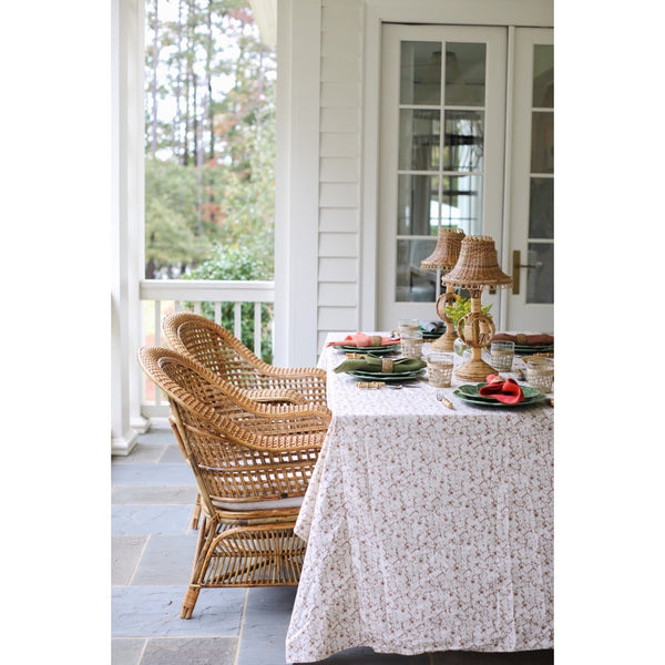 Outdoor dining area with wicker chairs and a table set for a meal.