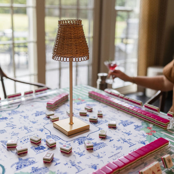 Board game with tiles and a lamp on a table in a room with large windows.