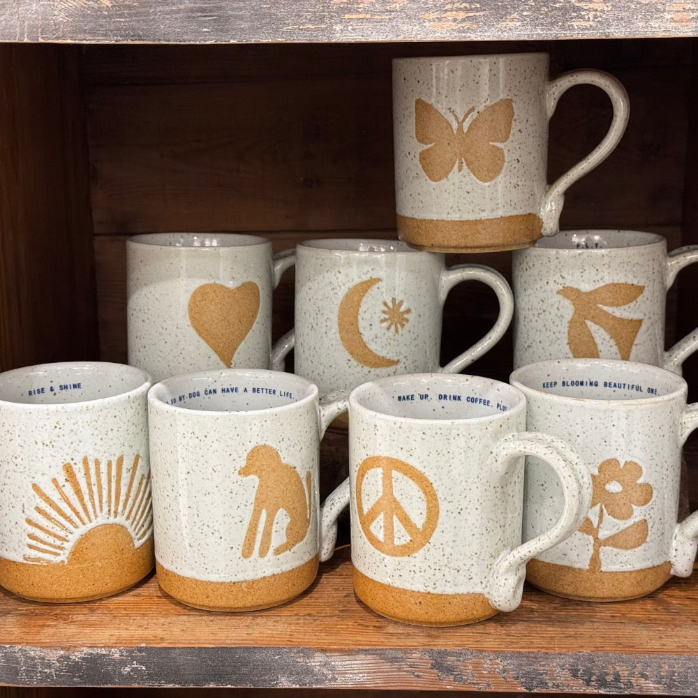 Sugarboo & Co.'s Happy Mug Collection features 8 handmade, speckled mugs with tan heart, butterfly, sun, or peace sign.