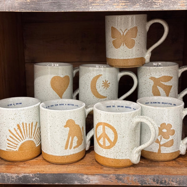 Sugarboo & Co.'s Happy Mug Collection features 8 handmade, speckled mugs with tan heart, butterfly, sun, or peace sign.