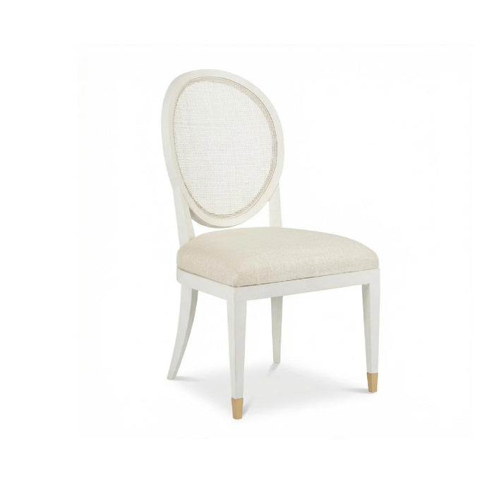 The Margo Cane Back Chair by Phillips Scott features an oval cane back, curved legs, and upholstered seat.