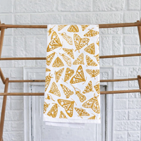 A Flour Sack Moths Kitchen Towel by Muse Textiles hangs on a wooden rack before a white brick wall.