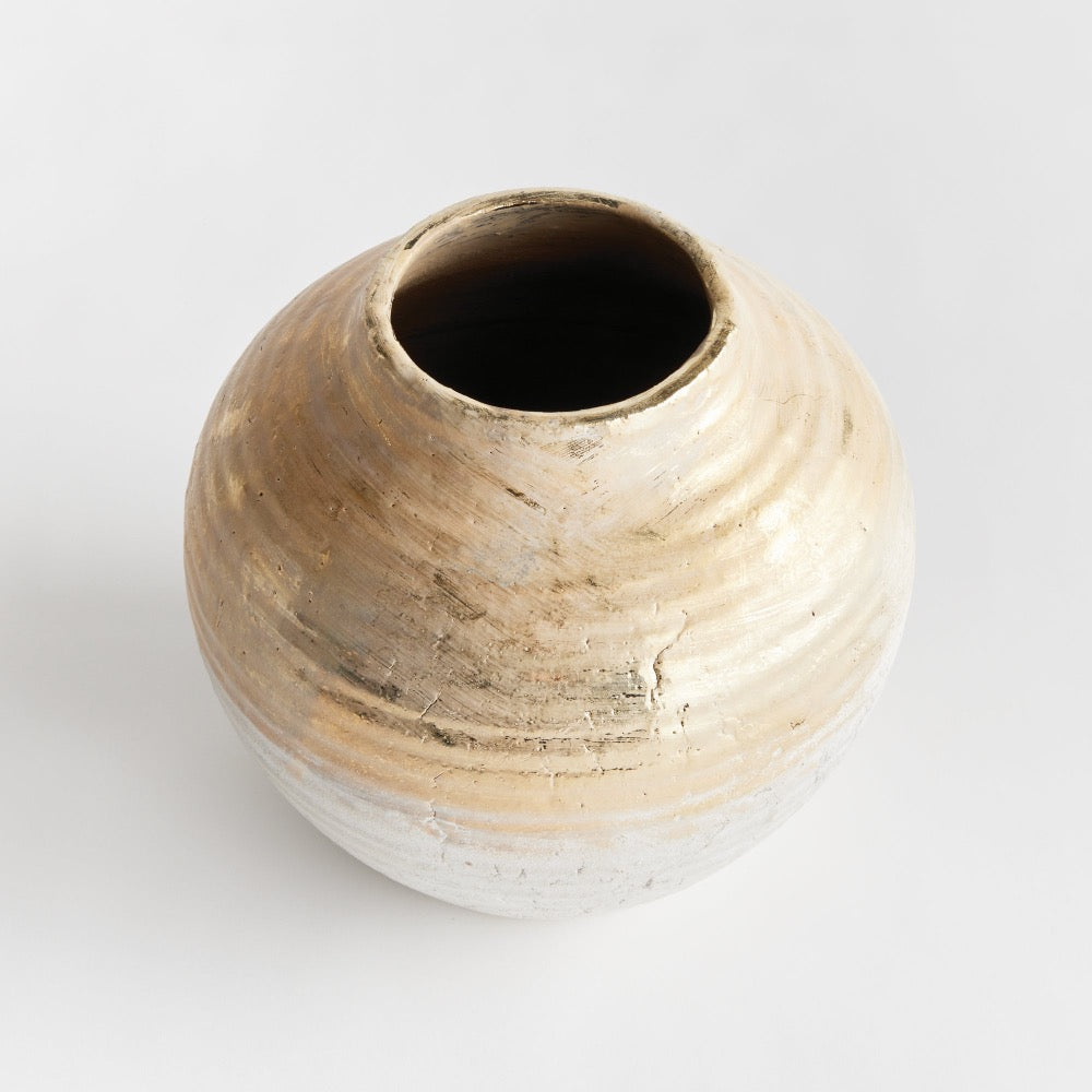 Small ceramic vase with a textured surface on a light gray background