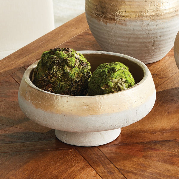 Decorative bowl with moss balls on a wooden surface