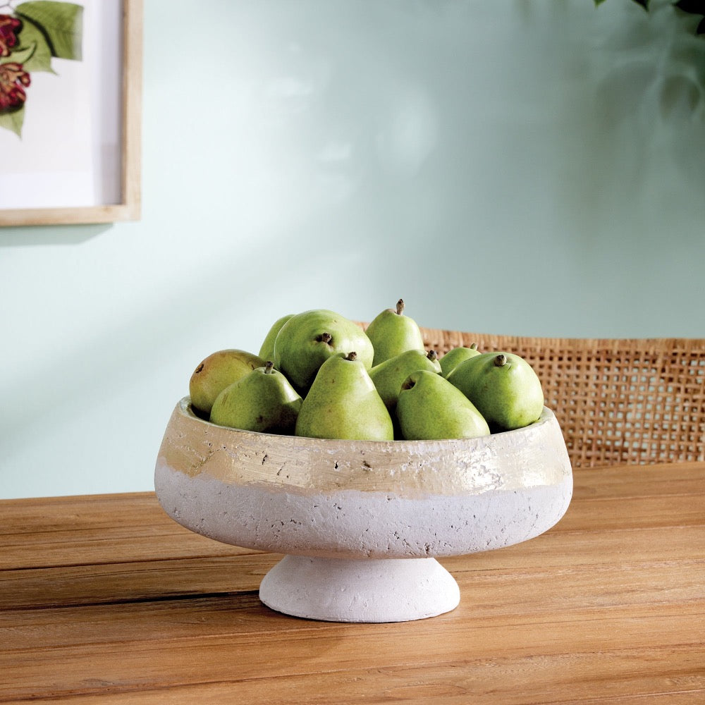 Bowl of green pears on a wooden table with a light blue wall in the background