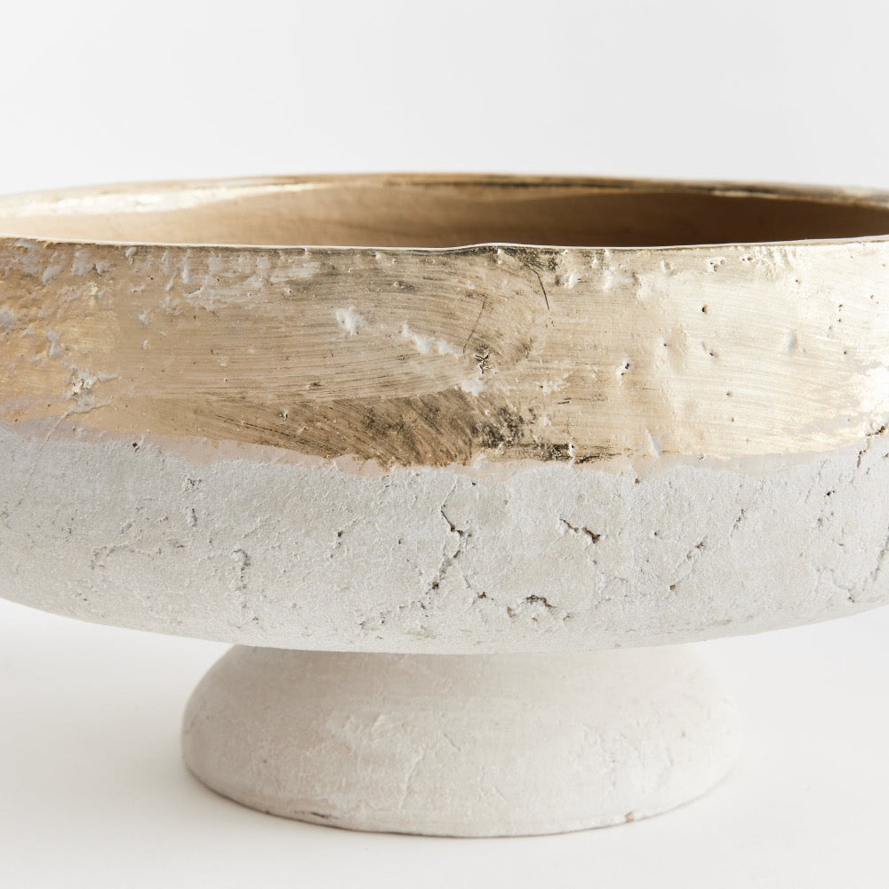 Decorative bowl with gold interior and stone base on a white background