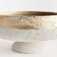 Decorative bowl with gold interior and stone base on a white background