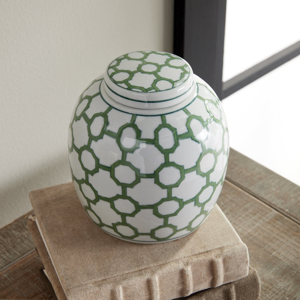 Green and white patterned jar on a wooden surface