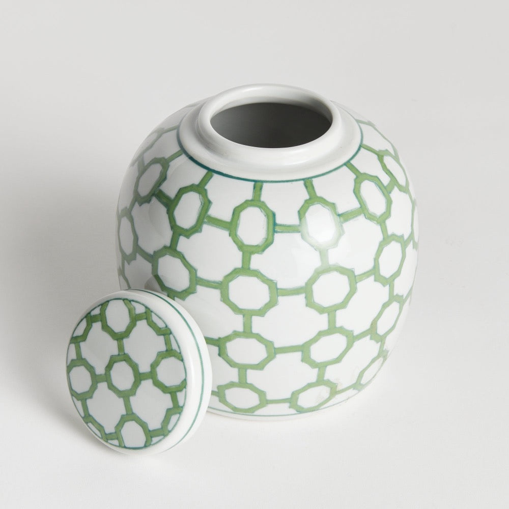 Ceramic jar with green geometric pattern on a light gray background