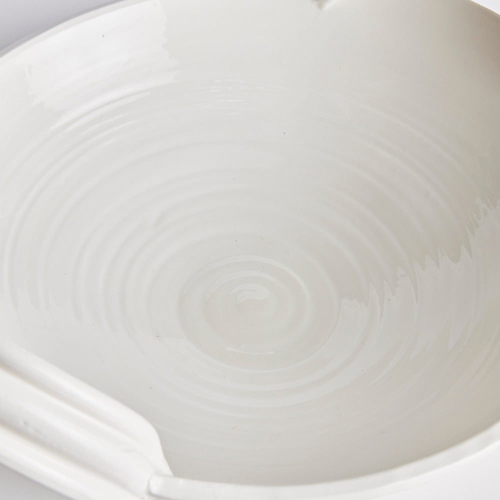 Close-up of a white ceramic bowl with subtle texture