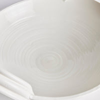 Close-up of a white ceramic bowl with subtle texture