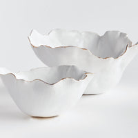 Two white ceramic bowls with ruffled edges on a light gray background