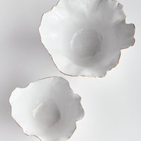 Two white ceramic plates with scalloped edges on a light gray background