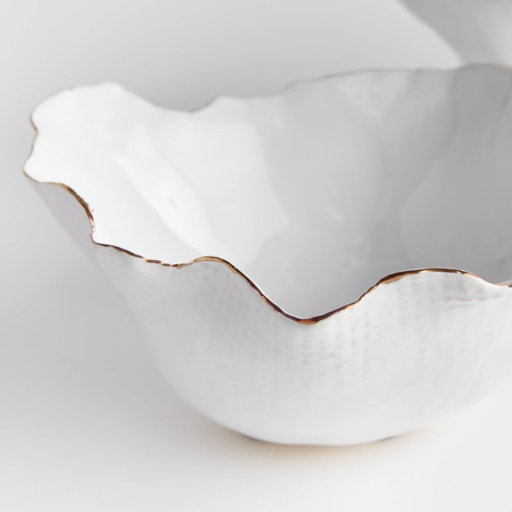 White ceramic bowl with scalloped edge on a light gray background