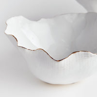 White ceramic bowl with scalloped edge on a light gray background