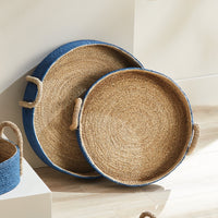 Set of woven trays with blue exterior on a light wooden surface
