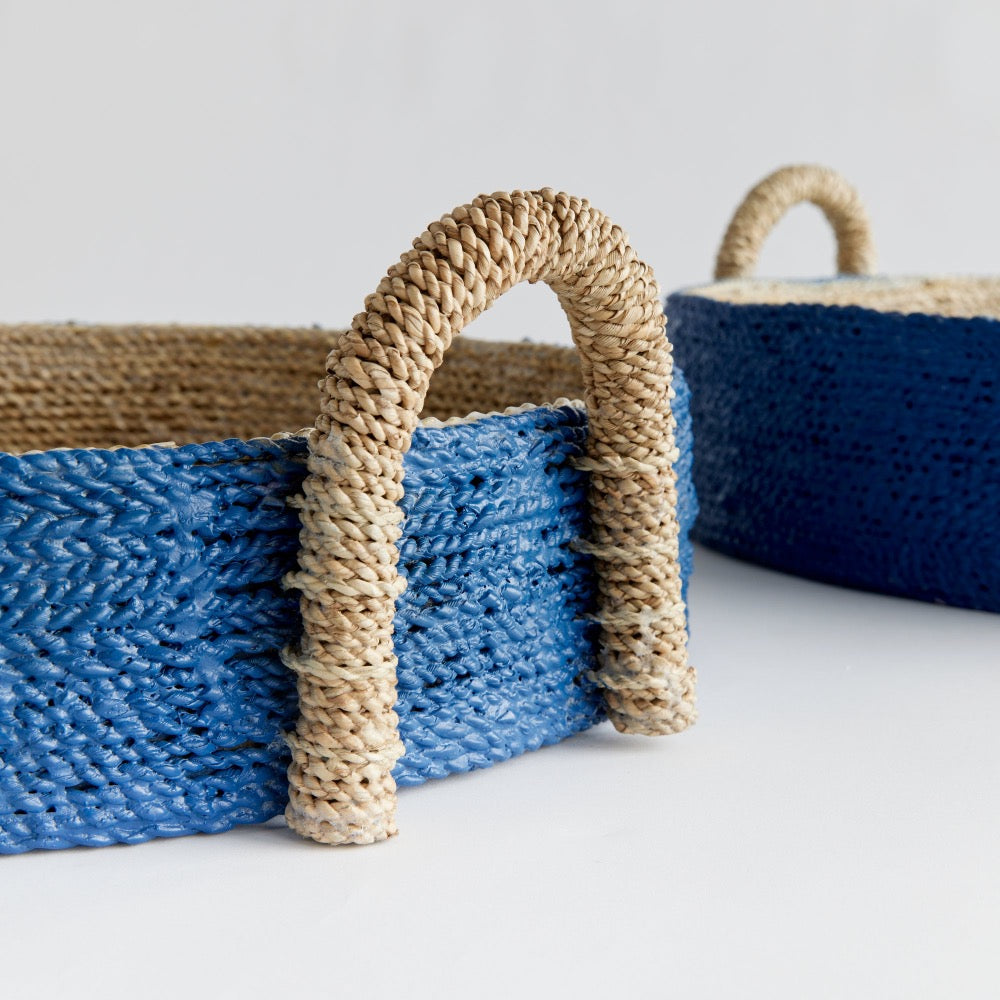 Blue woven basket with natural handle on a light background