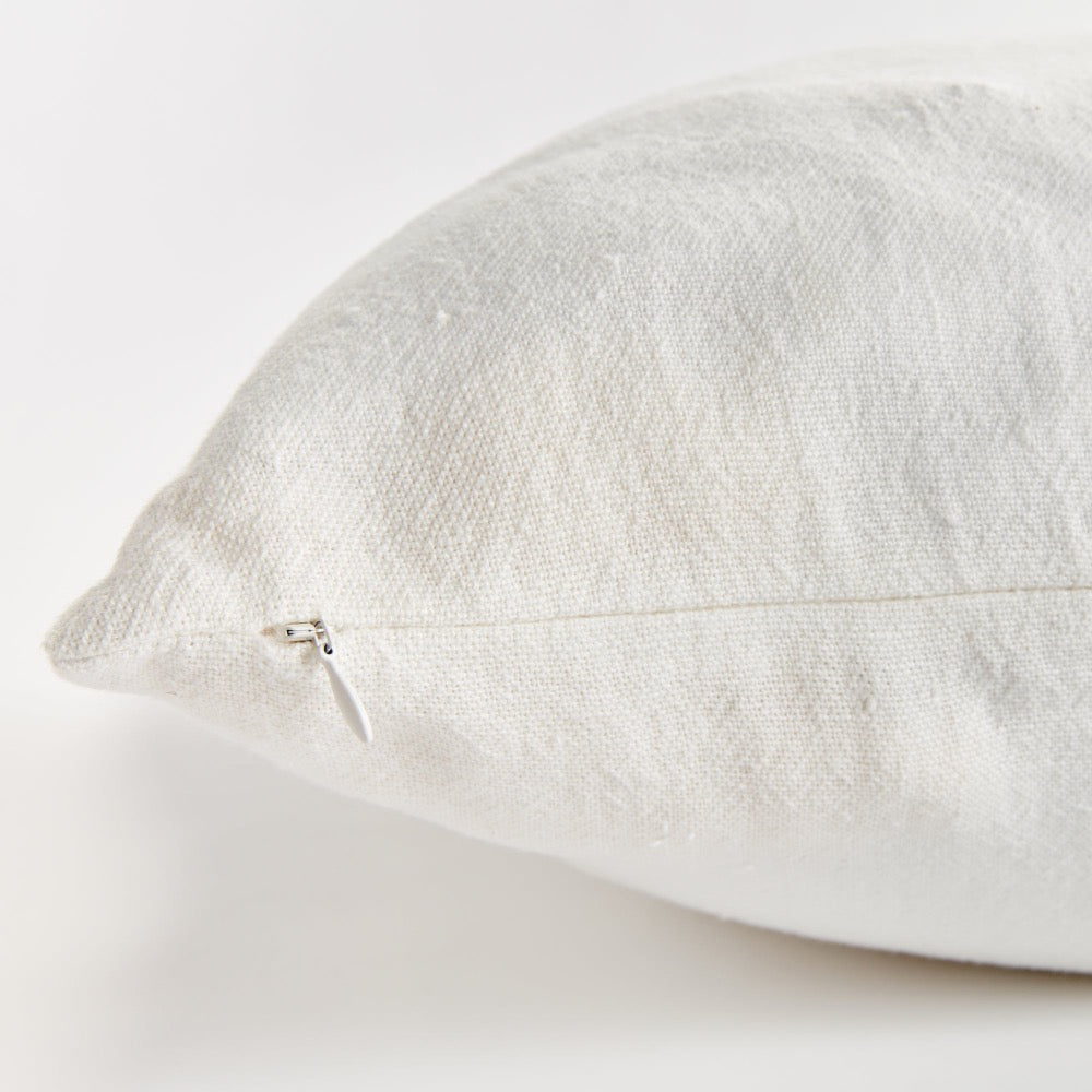 Close-up of a textured white pillow on a light gray background
