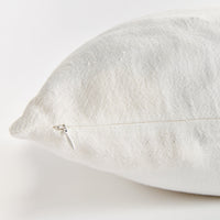 Close-up of a textured white pillow on a light gray background