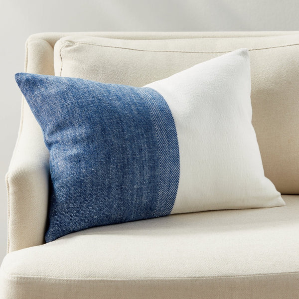 Decorative pillow with blue and white sections on a beige sofa.