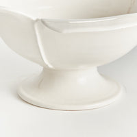 White ceramic pedestal bowl on a white background