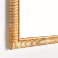 Close up of rattan mirror with a wicker frame on a white background