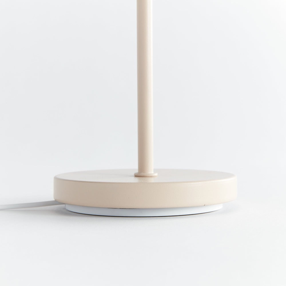 Beige table lamp base on a white surface with a light gray background