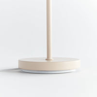 Beige table lamp base on a white surface with a light gray background