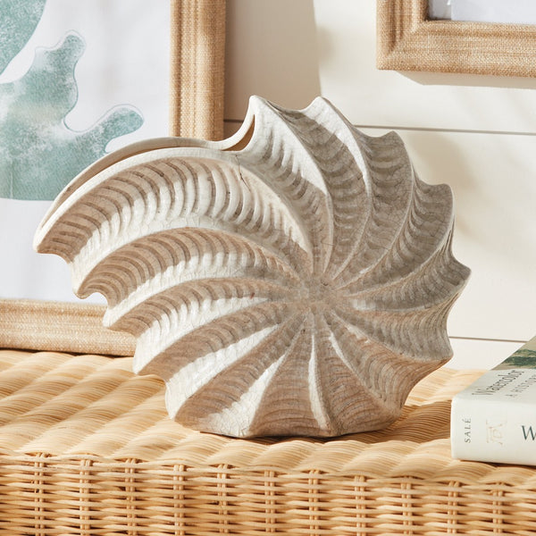 Decorative shell vase on a wicker surface.