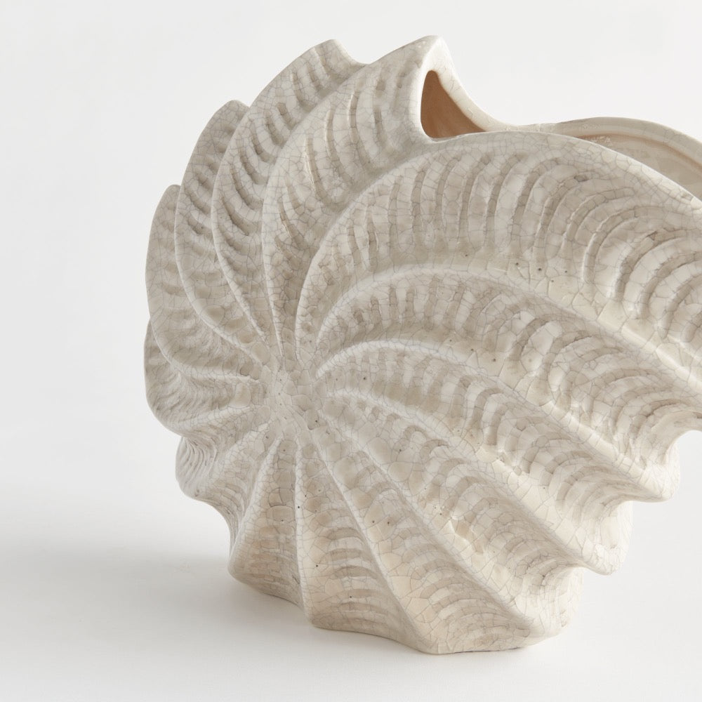 Decorative vase with shell-like design on a white background